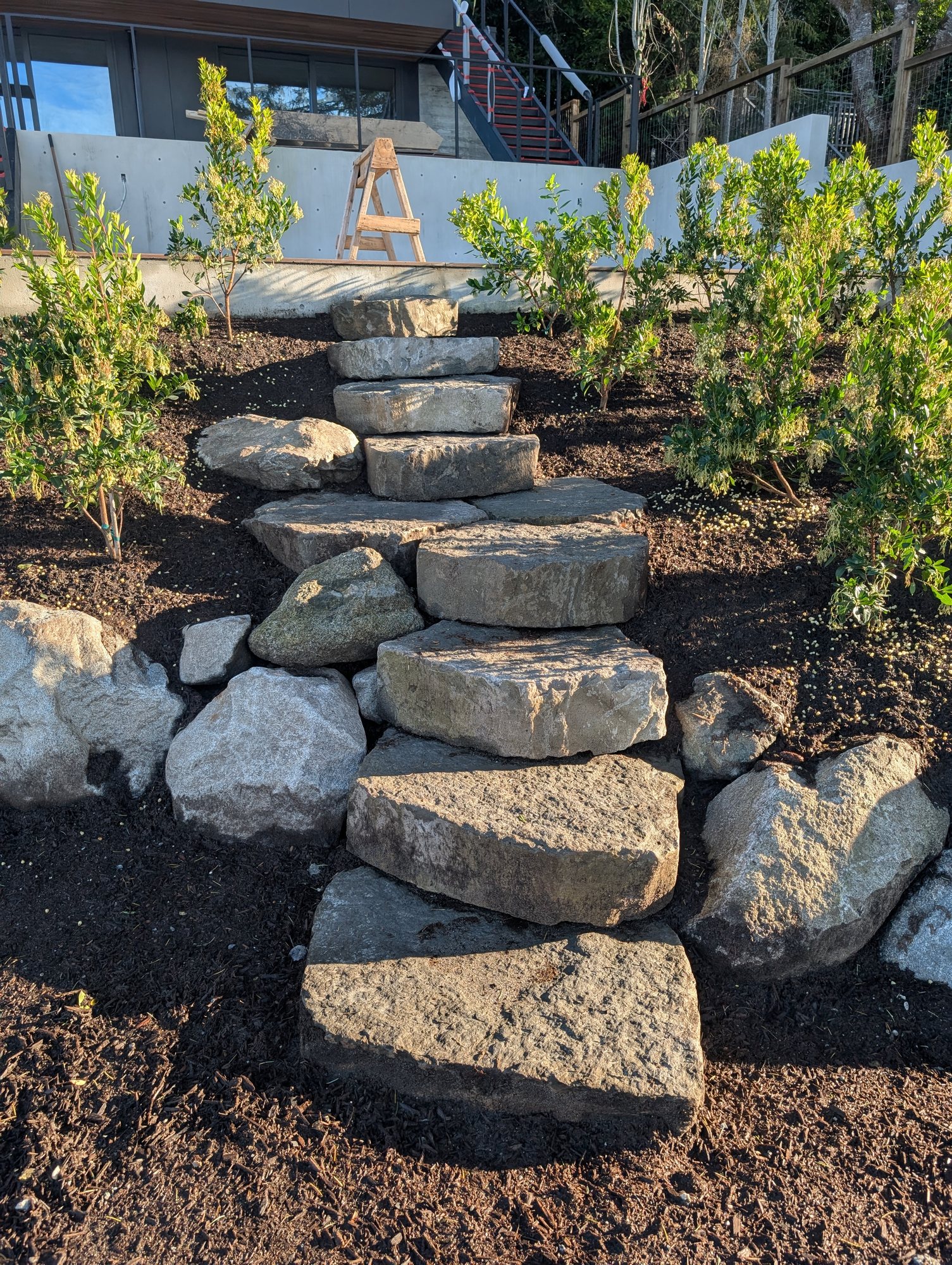 Natural stone boulder steps set into a planted hillside