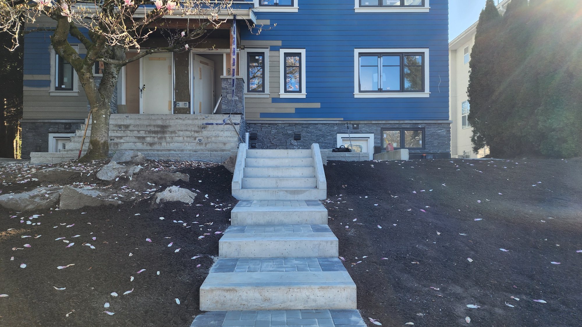 Custom concrete and paver staircase leading up to a new home